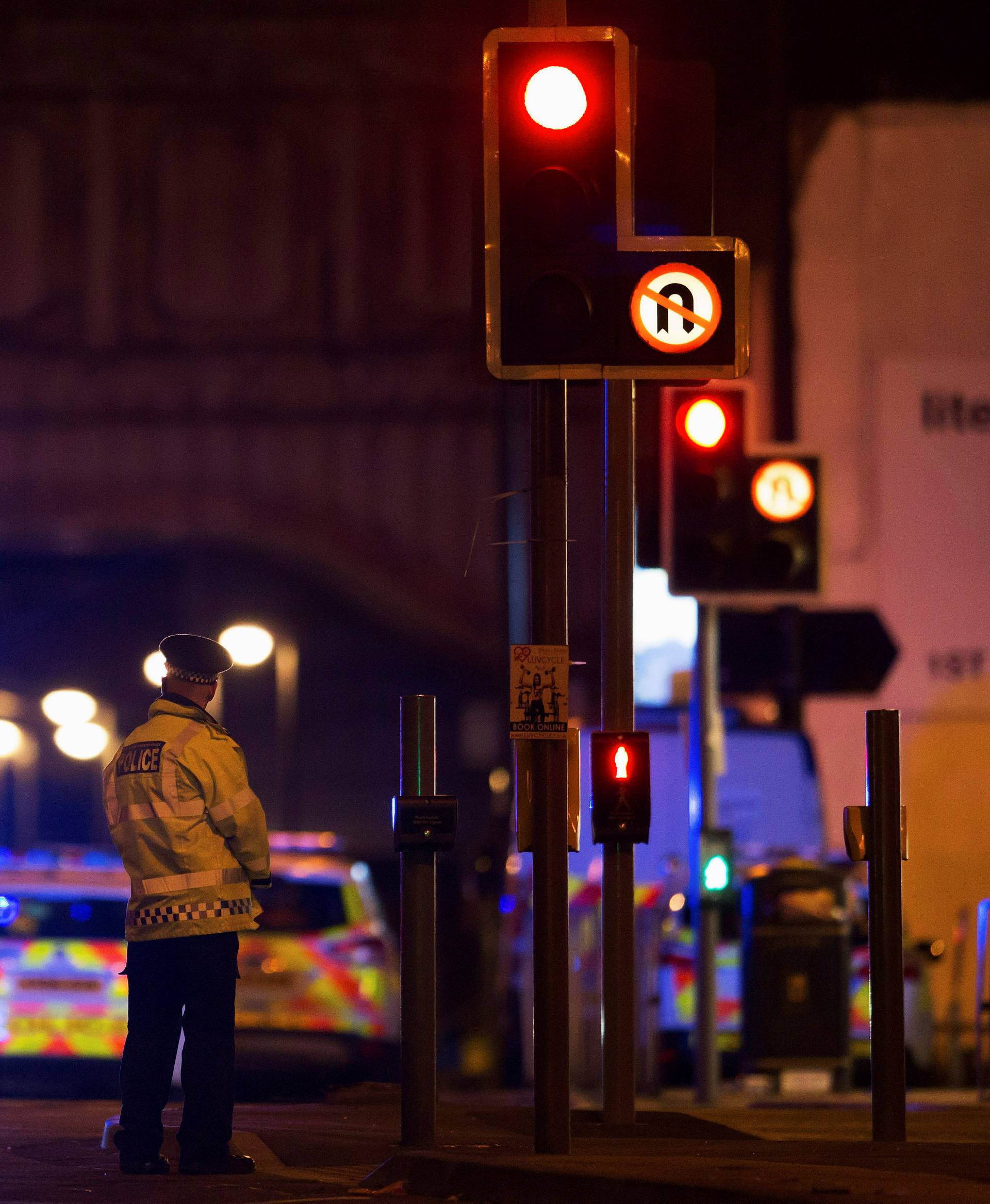 Police vehicles and a police officer are seen outside the Manchester Arena, where U.S. singer Ariana Grande had been performing in Manchester, northern England, Britain