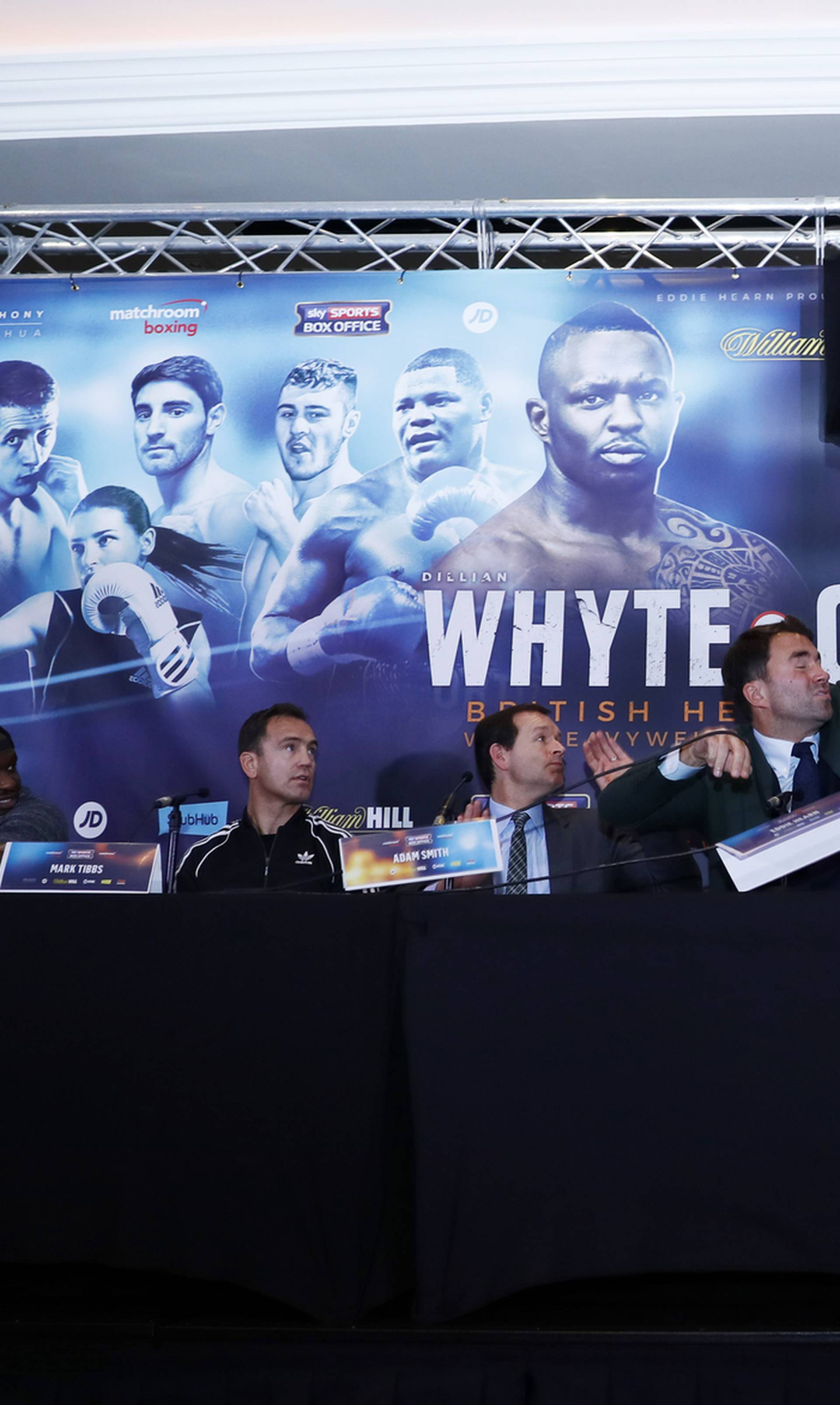 Dillian Whyte, trainer Mark Tibbs, Sky Sports' Adam Smith, promoter Eddie Hearn and promoter Kalle Sauerland look on as Dereck Chisora throws a table during the press conference