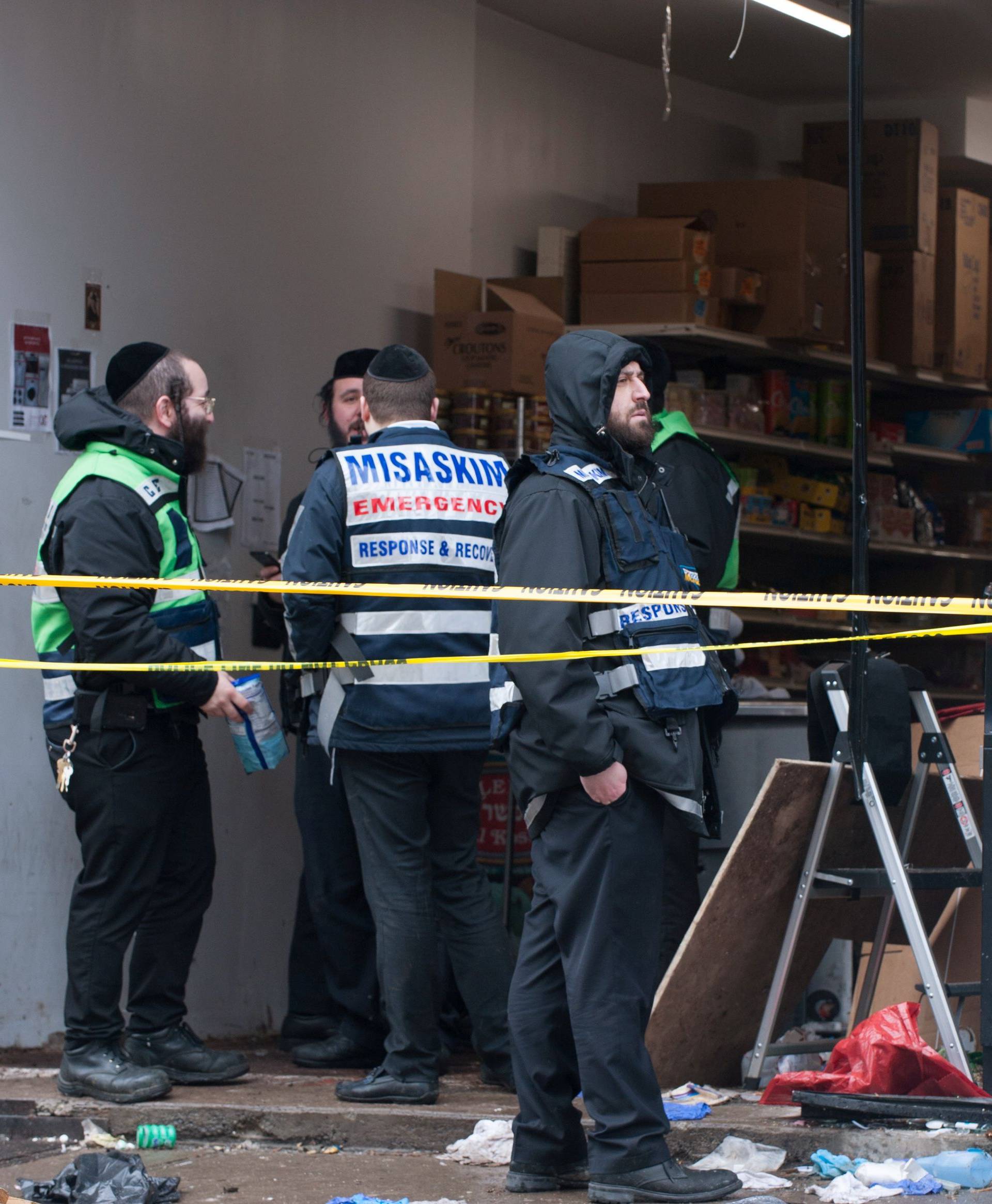 Emergency personnel and investigators work at the scene the day after an hours-long gun battle with two men around a kosher market in Jersey City, New Jersey
