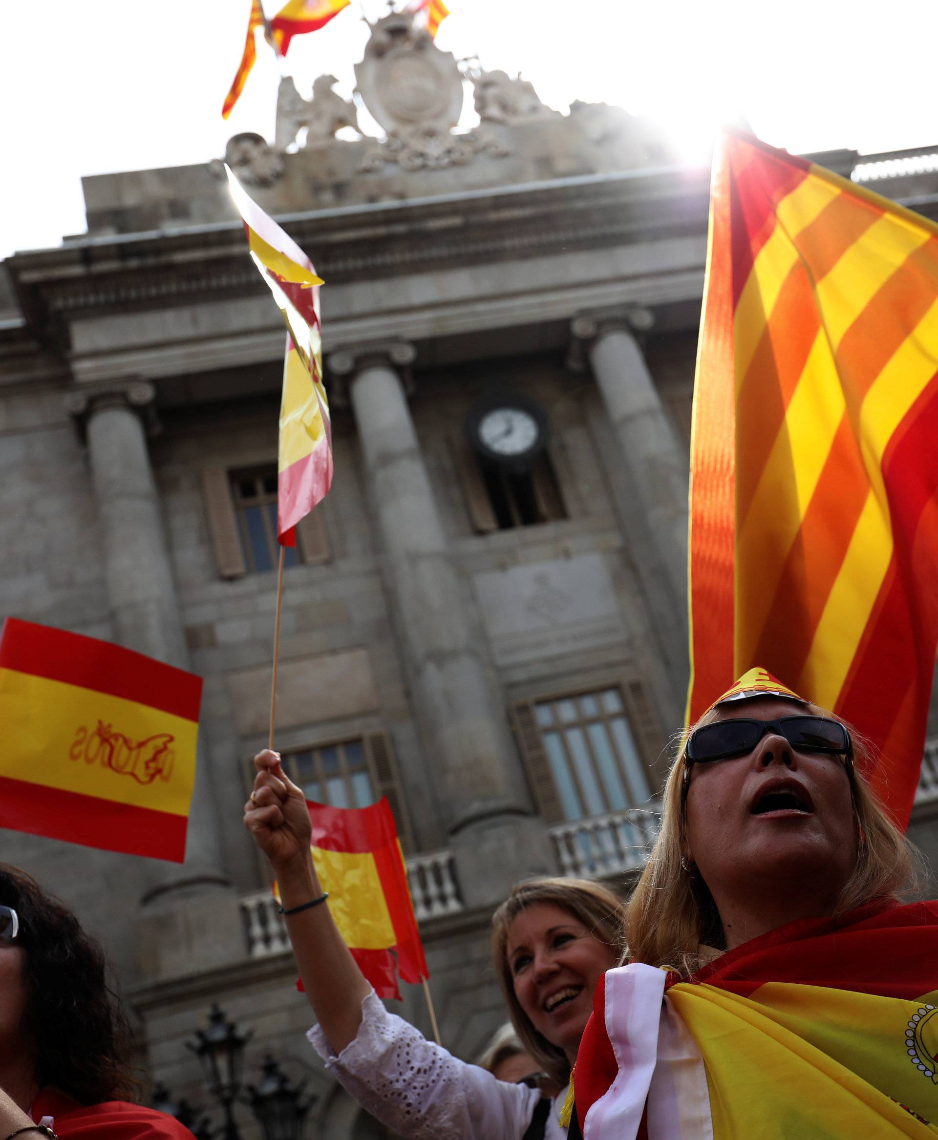 People hold up Spanish and Catalan flags during a demonstration in favor of a unified Spain a day before the banned October 1 independence referendum, in Barcelona