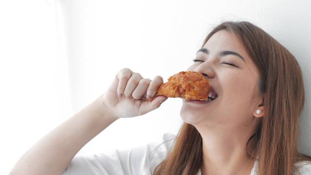 Asian,Beautiful,Woman,Enjoy,Eating,With,Fried,Chicken,On,White