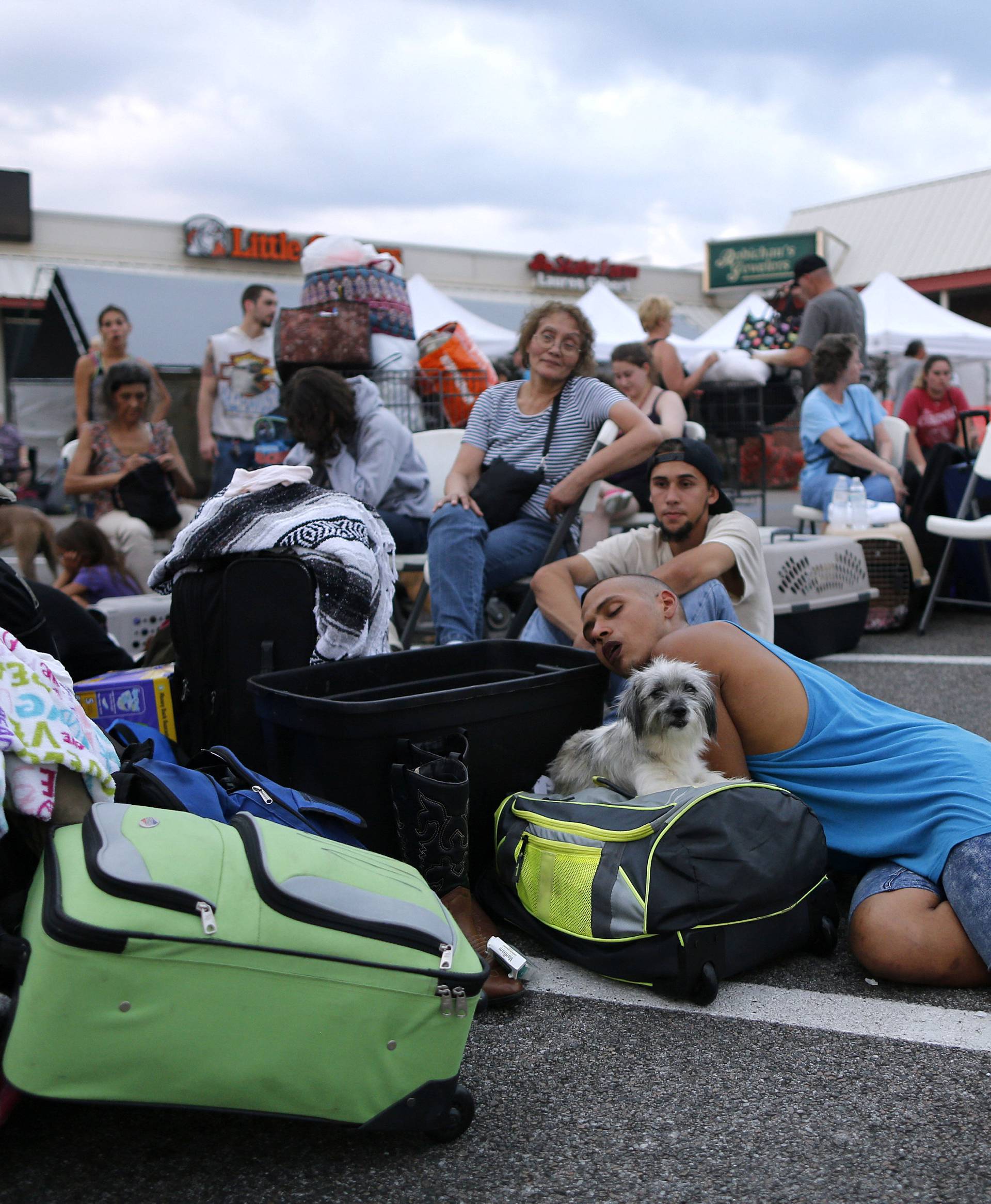 Evacuees who were rescued from the flood waters of Tropical Storm Harvey wait to board school buses bound for Louisiana in Vidor, Texas