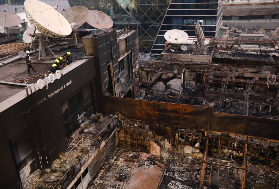 Fire fighters inspect the restaurants destroyed in a fire in Mumbai