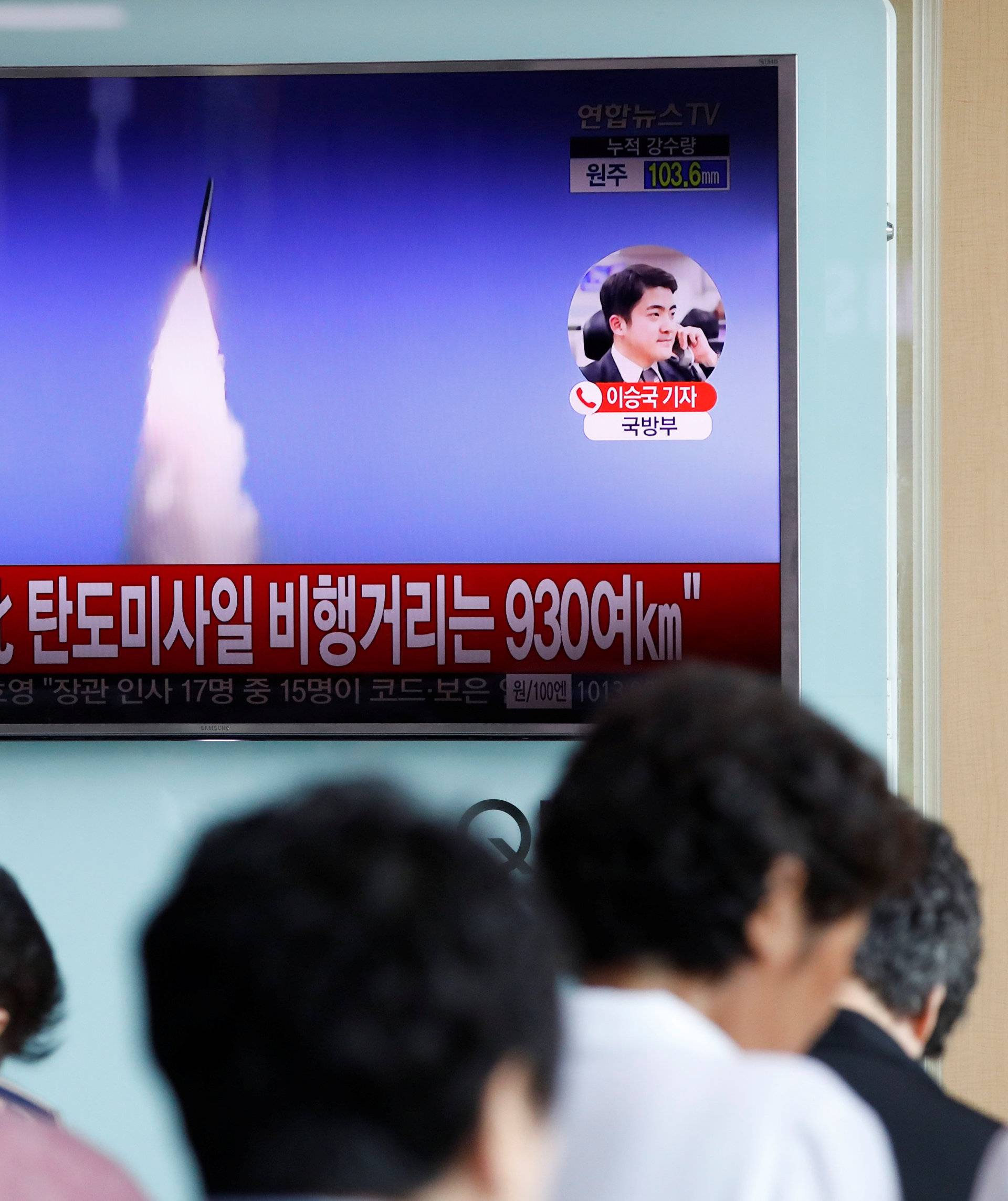 People watch a TV broadcast of a news report on North Korea's ballistic missile test, at a railway station in Seoul