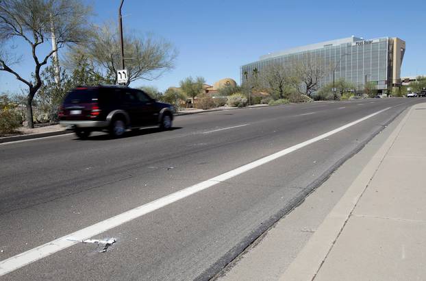 Burned out flares lie at the location where a woman pedestrian was struck and killed by an Uber self-driving sport utility vehicle in Tempe