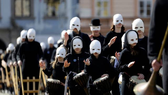People wearing masks blow horns in front of a church during Easter celebrations in Ceske Budejovice, Czech Republic, April 15, 2022. REUTERS/David W Cerny Photo: DAVID W CERNY/REUTERS