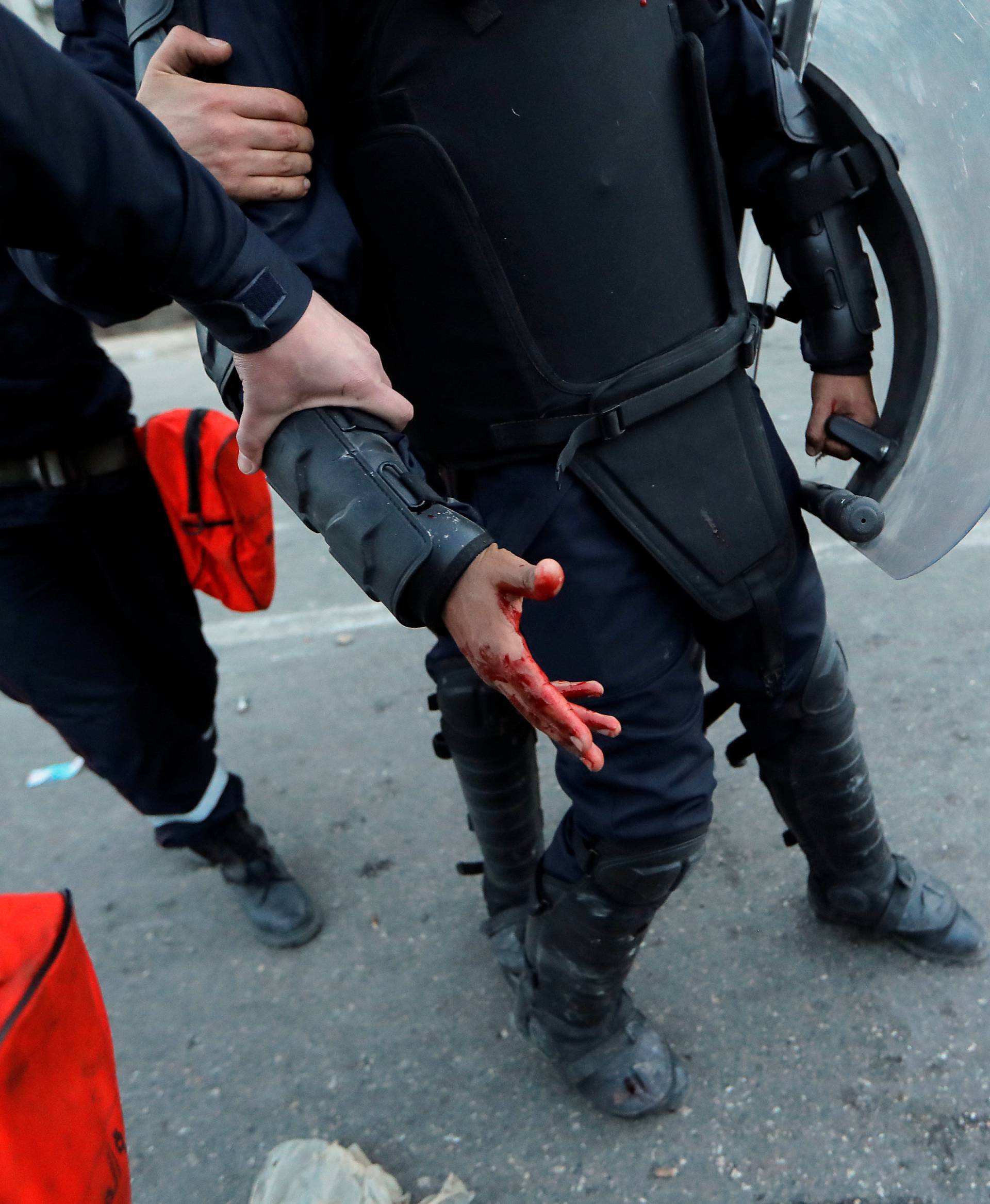 An injured anti riot-police officer is seen during clashes with people protesting against President Abdelaziz Bouteflika's plan to extend his 20-year rule by seeking a fifth term in April elections in Algiers