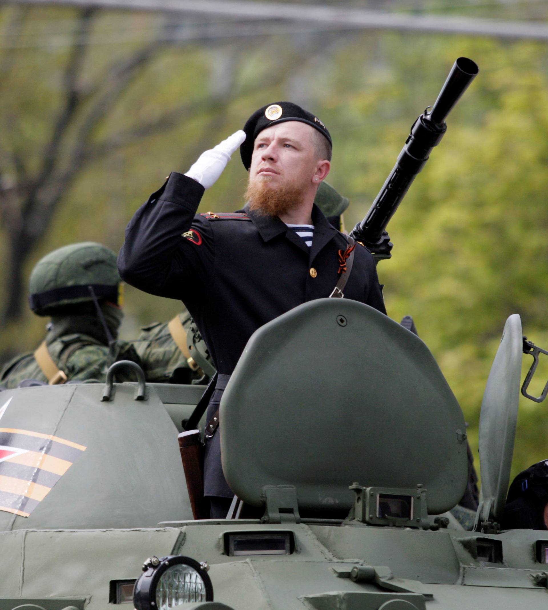 Former pro-Russian separatist Pavlov sits atop of an armoured personnel carrier during the Victory Day parade to mark the end of World War Two, in Donetsk