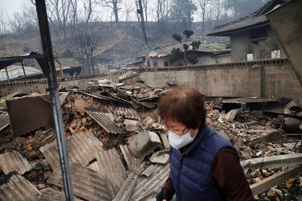 Kun Yeong-nam, 72, walks at her burnt house after a wildfire devastated the area in Uiseong