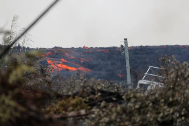 Molten rock from the Kilauea volcano pours down the side of the lava flow on Pohoiki Road near Pahoa, Hawaii