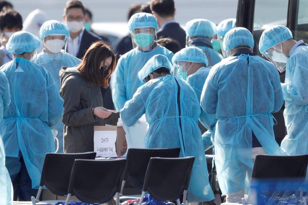 Passengers wearing masks leave cruise ship Diamond Princess at Daikoku Pier Cruise Terminal in Yokohama