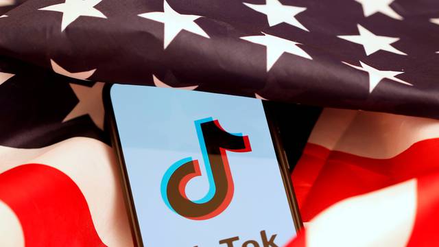 FILE PHOTO: Tik Tok logo is displayed on the smartphone while standing on the U.S. flag in this illustration