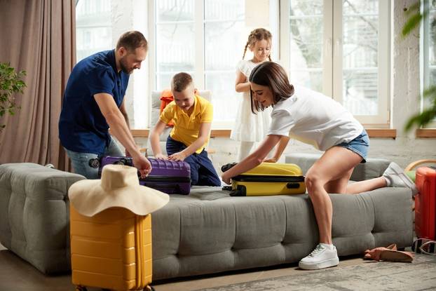 Man,,Woman,,Boy,And,Girl,Sorting,Garments,For,Travel,,Nd