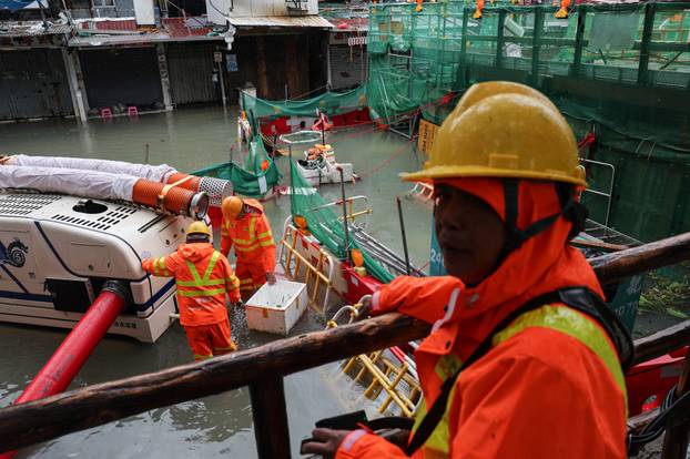Workers use a robotic pump to remove floodwater from inundated areas in the aftermath of Super Typhoon Ragasa in Hong Kong