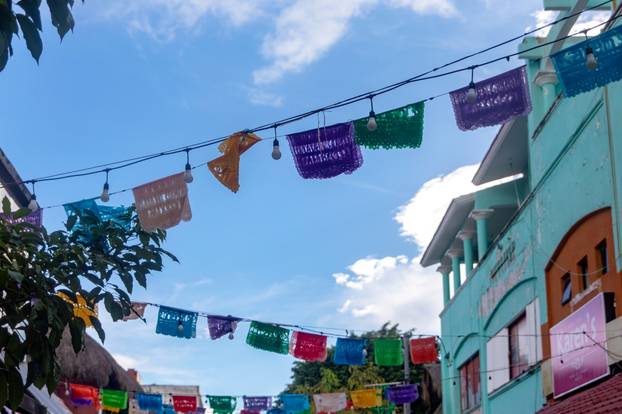 Playa del Carmen, Mexico, April 2, 2023: Flags on the fifth avenue of the Mexican city of Playa del Carmen, the most commercial street of this Mexican town which is full of tourists and foreigners.