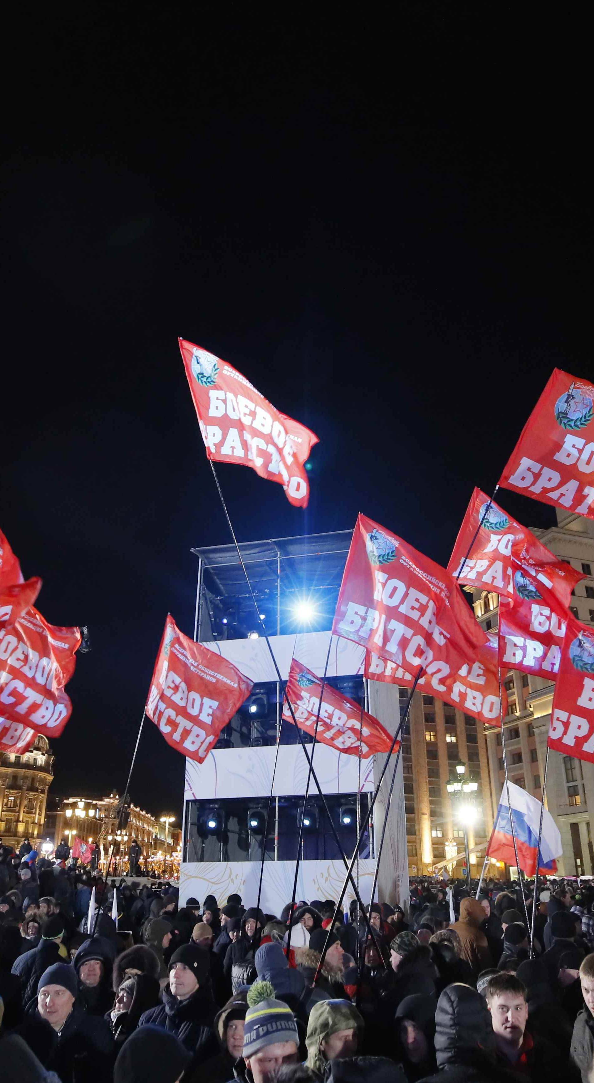 People attend a rally and concert marking the fourth anniversary of Russia's annexation of the Crimea region, at Manezhnaya Square in central Moscow