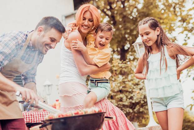 Happy,Young,Family,Barbecuing,Meat,On,The,Grill.