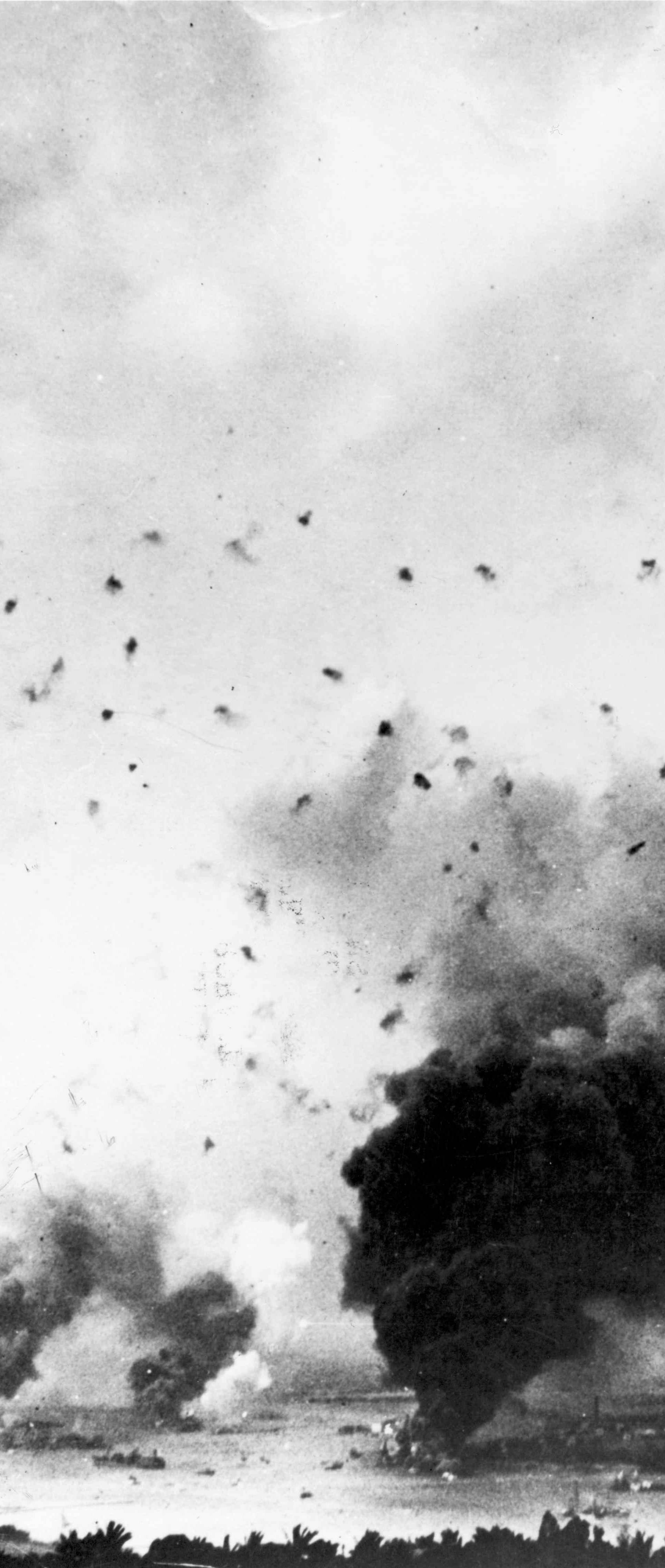 Archive photo of flak bursts above rising smoke from the battleship USS Arizona during the Japanese raid on Pearl Harbor