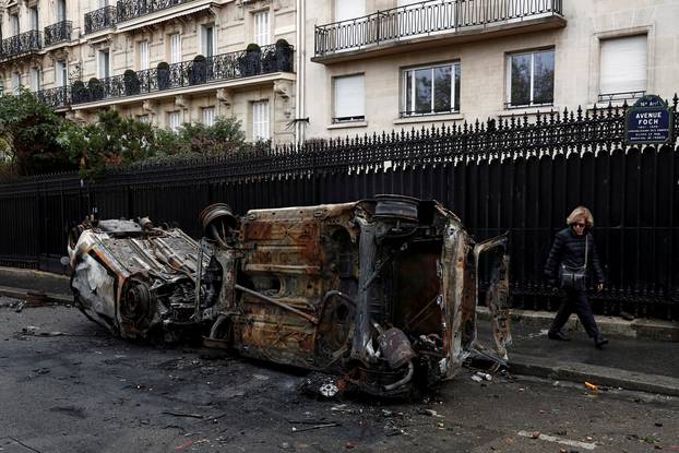 Vandalized cars are seen on a street the morning after clashes with protesters wearing yellow vests, a symbol of a French drivers