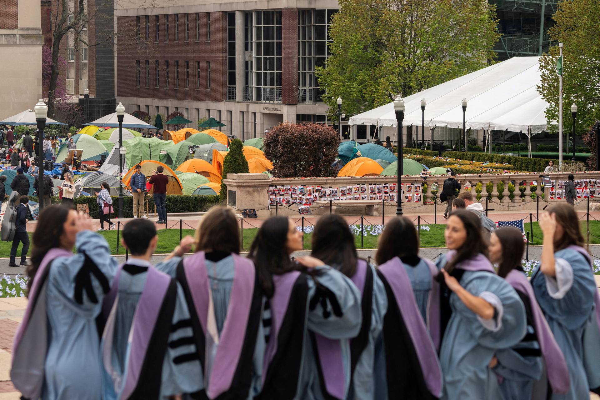 Students wearing gowns stand as students continue to maintain a protest encampment on the main campus of Columbia University in support of Palestinians, in New York City