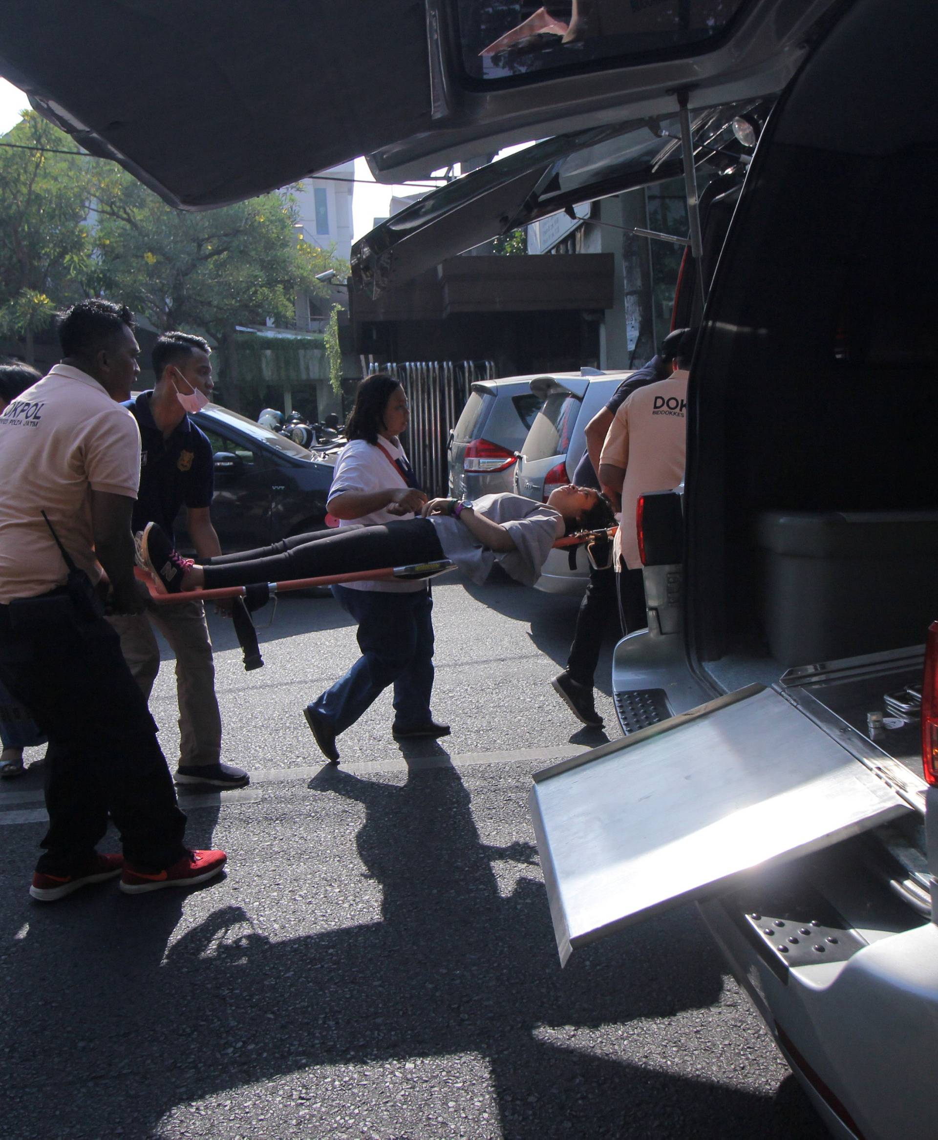 A person injured from a blast at the Indonesian Christian Church is evacuated to a waiting ambulance in Surabaya, East Java,