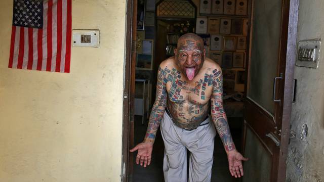 Guinness Rishi, multiple world record holder including most flags tattooed on his body, poses for a photograph outside his apartment in New Delhi
