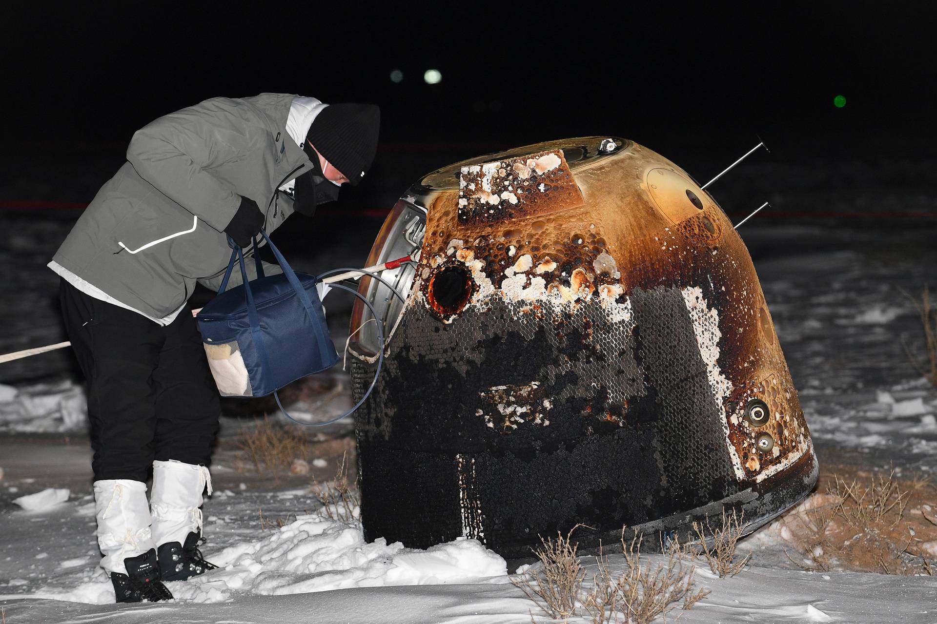 Researcher works next to Chang'e-5 lunar return capsule carrying moon samples after it landed in northern China's Inner Mongolia Autonomous Region