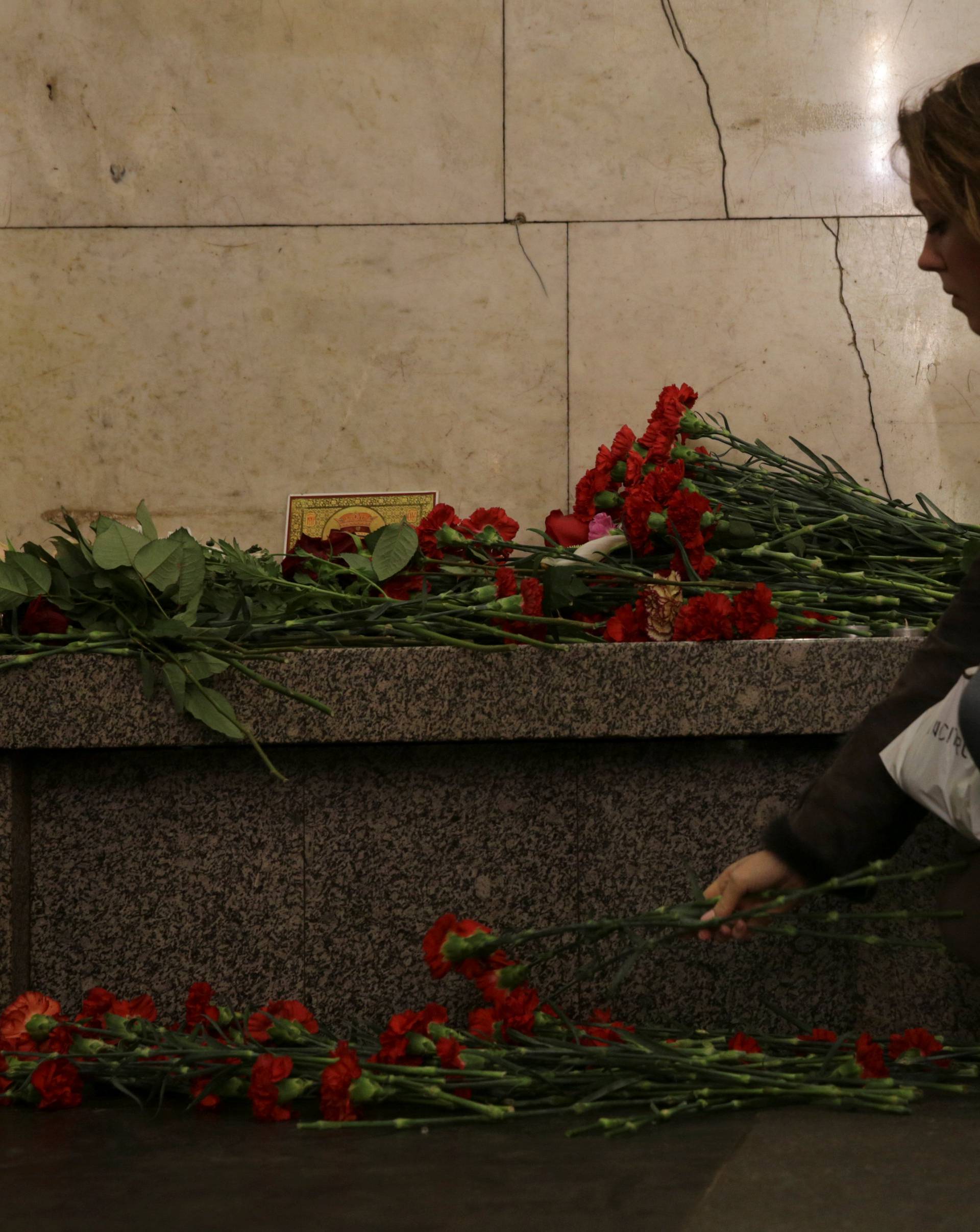 A woman lays flowers in memory of victims of a blast in St.Petersburg metro, at Tekhnologicheskiy institut metro station in St. Petersburg