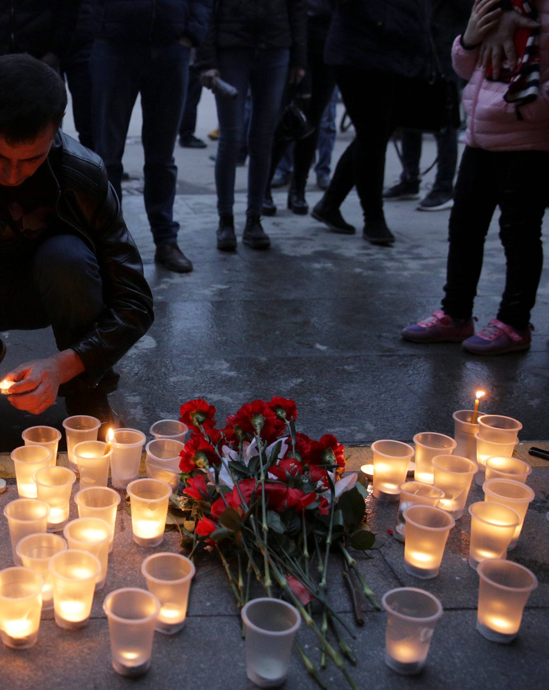 A man lights a candle during a memorial service for victims of a blast in St.Petersburg metro, outside Spasskaya metro station in St. Petersburg