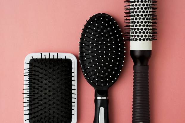 Used Hair brush tools on pink or coral background with copy space. Beauty fashion, hair care background.
