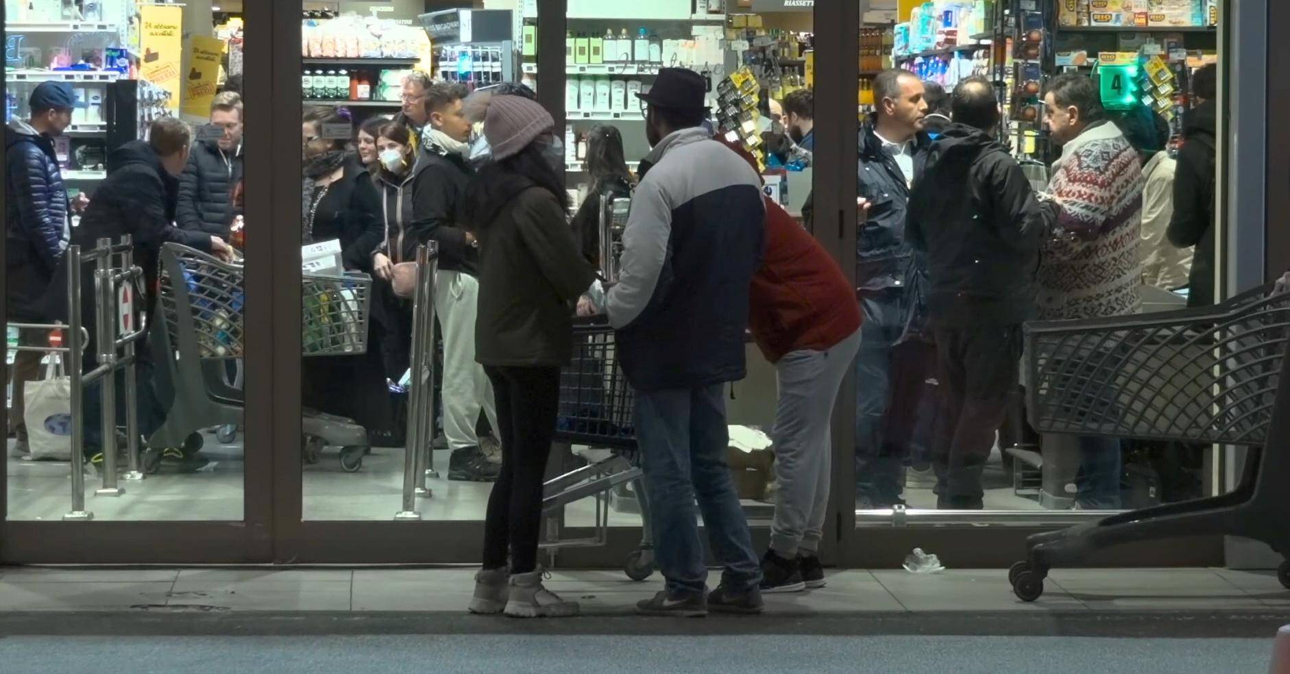 Crowds of people cram into a supermarket in the early hours of the morning in Rome