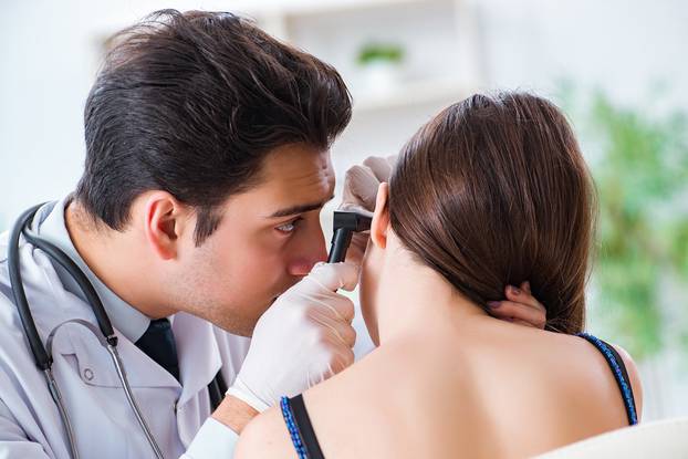 The doctor checking patients ear during medical examination