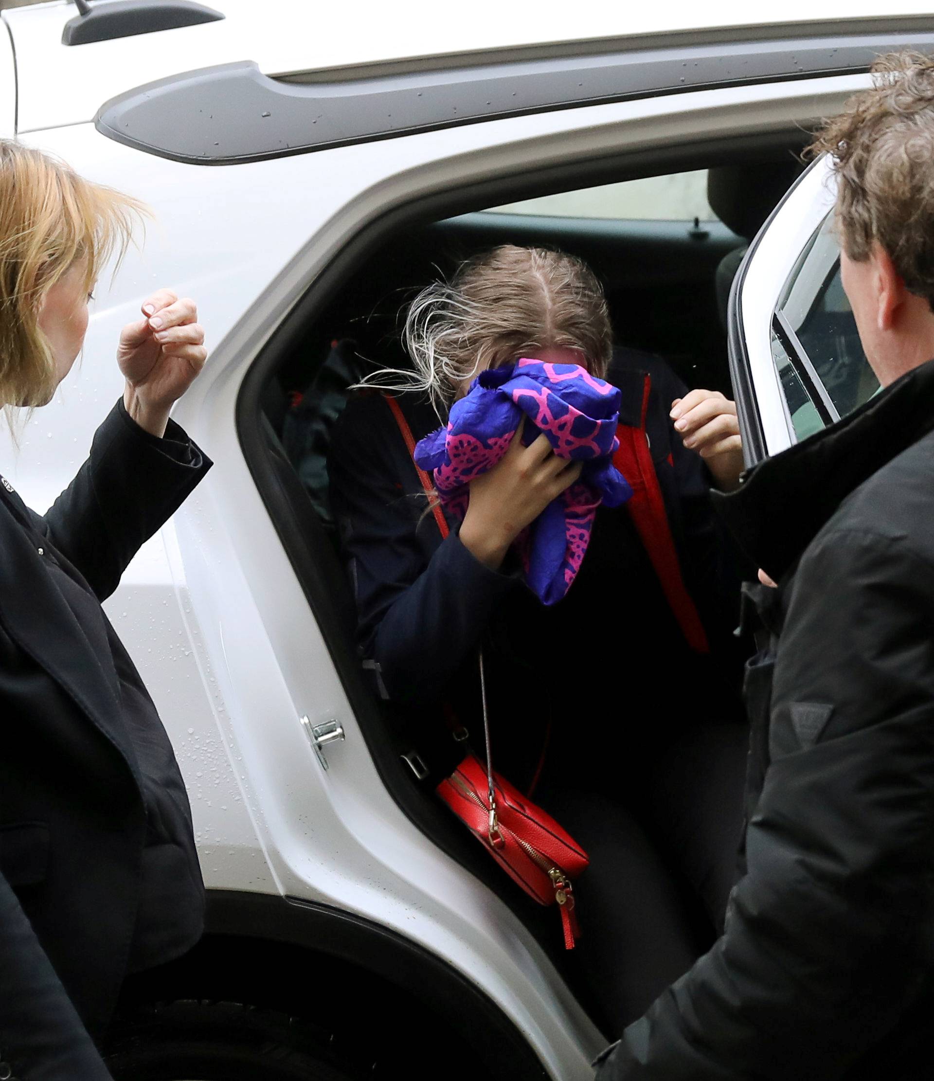 A British woman, accused of lying about being gang raped, covers her face as she arrives at the Famagusta courthouse in Paralimni