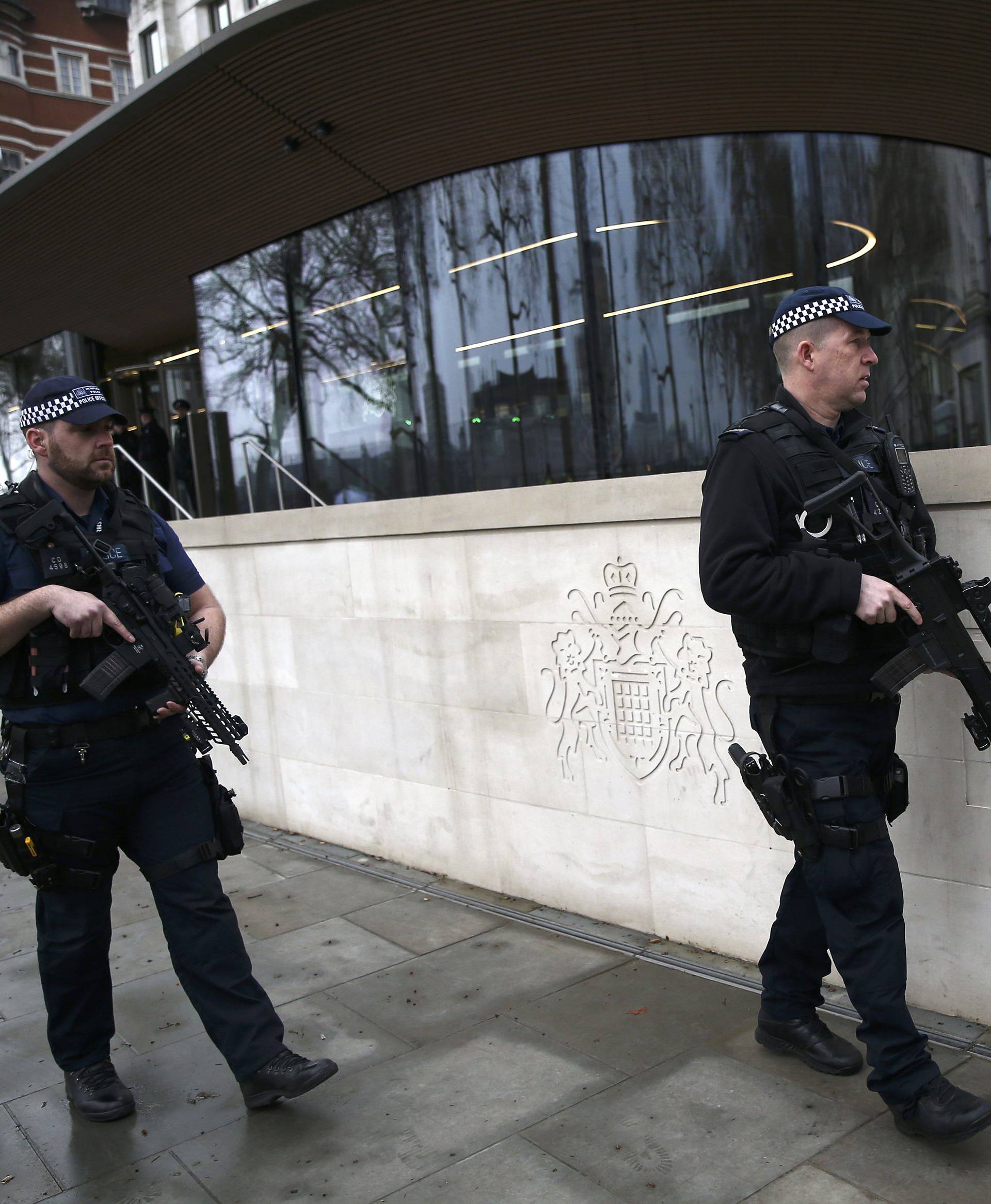 Armed police officers patrol outside New Scotland Yard the morning after an attack by a man driving a car and weilding a knife left five people dead and dozens injured, in London