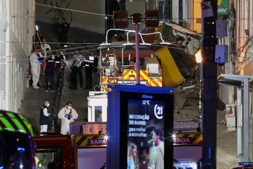 First responders work at the site of a funicular accident in Lisbon