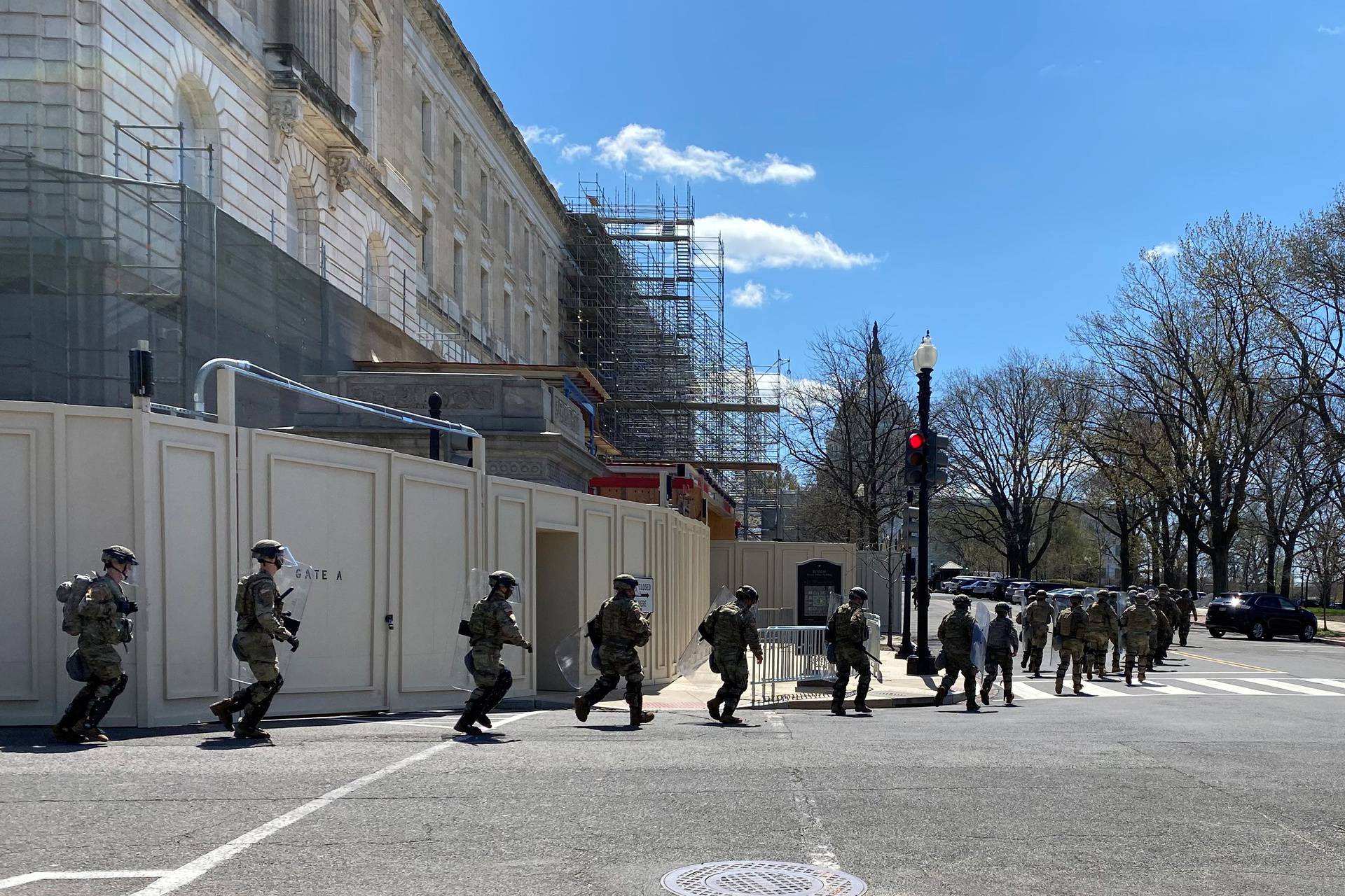 National Guard troops run towards the U.S. Capitol during a security incident in Washington