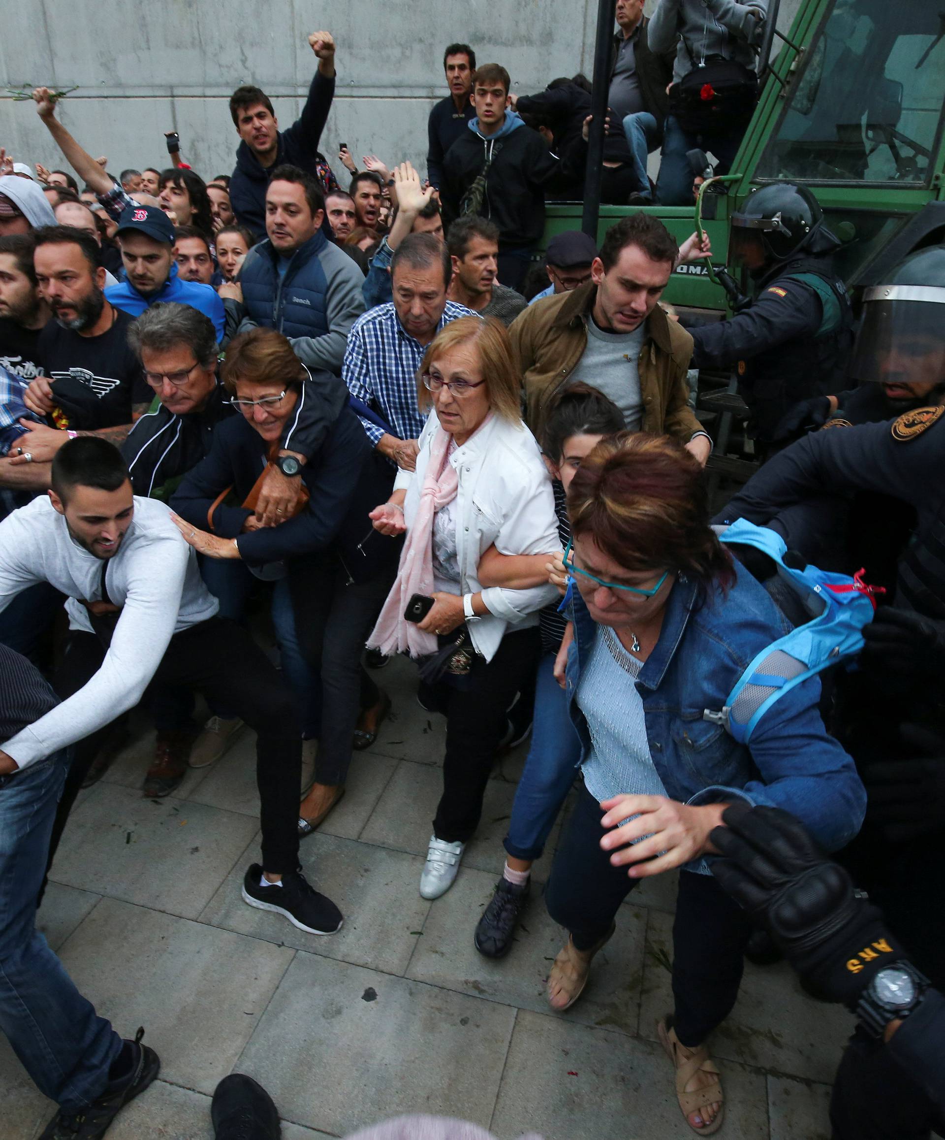 Spanish Civil Guard officers disperse people from the entrance of a polling station for the banned independence referendum in Sant Julia de Ramis