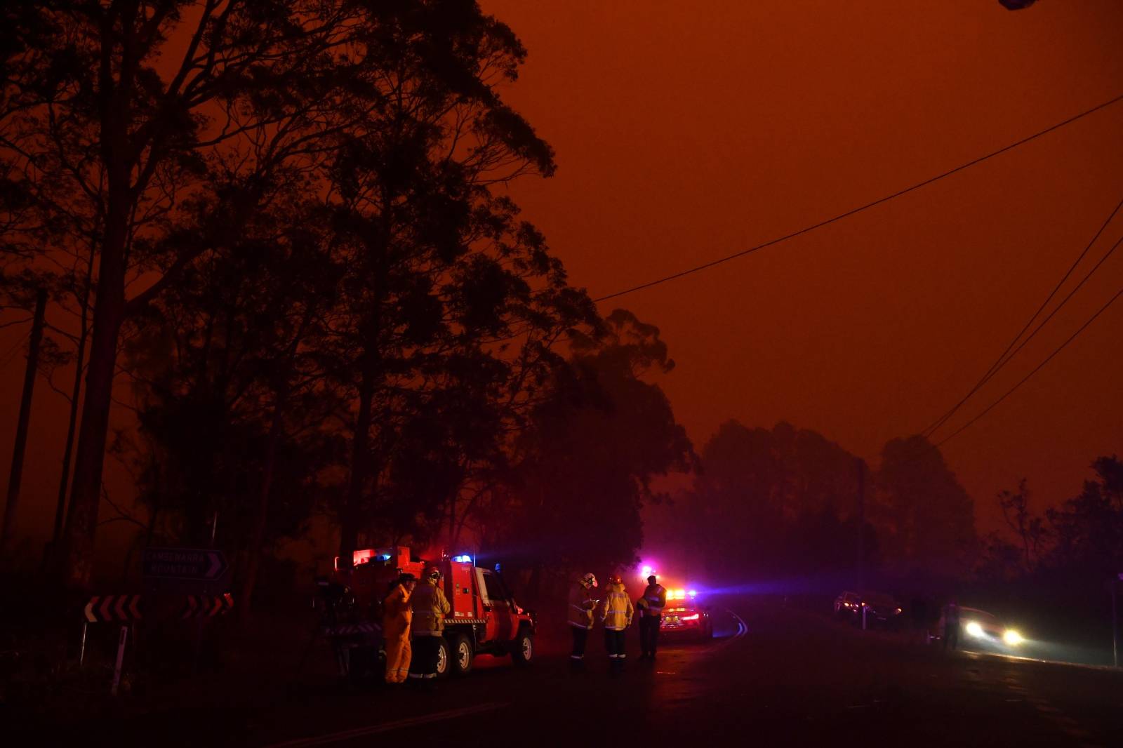Rural Fire Service personnel works at a roadblock near a bushfire in North Nowra, south of Sydney