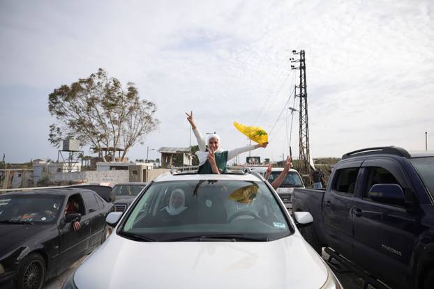 Displaced people cross the bridge linking southern Lebanon to the rest of the country, which was hit earlier in an Israeli strike, in Qasmiyeh