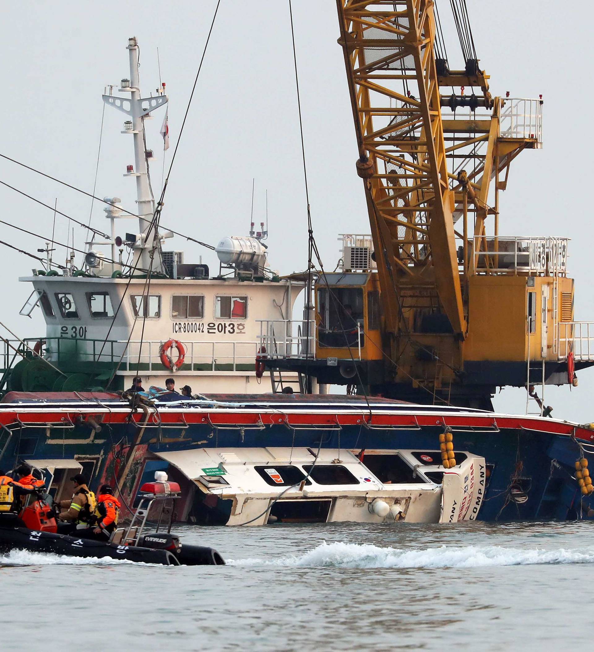 A capsized fishing boat is lifted during its salvation operation in the sea off Incheon
