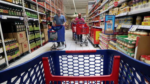 FILE PHOTO: People push a shopping cart in a Carrefour supermarket in Cabrera de Mar