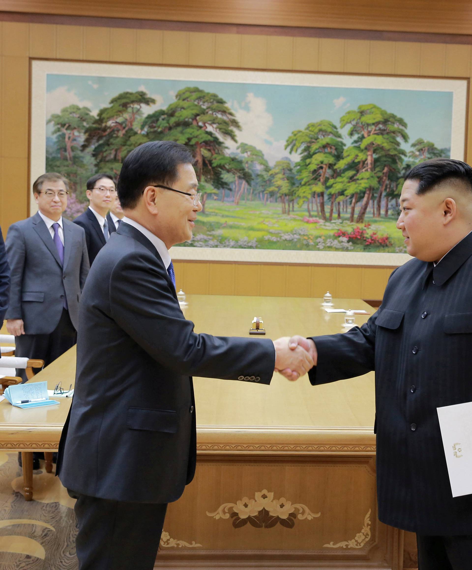 North Korean leader Kim Jong Un shakes hands with a member of the special delegation of South Korea's President