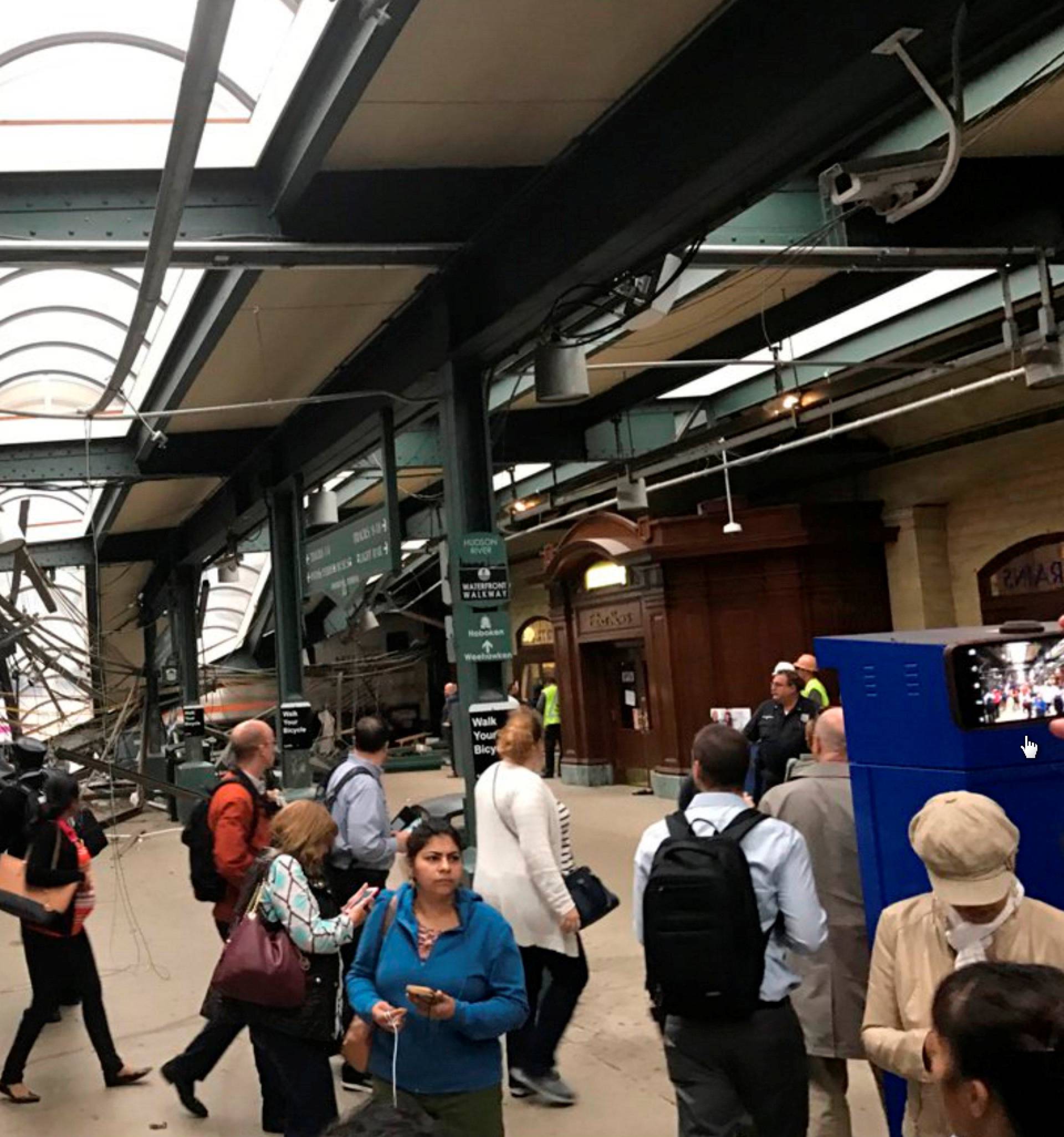 Onlookers view a New Jersey Transit train that derailed and crashed through the station in Hoboken