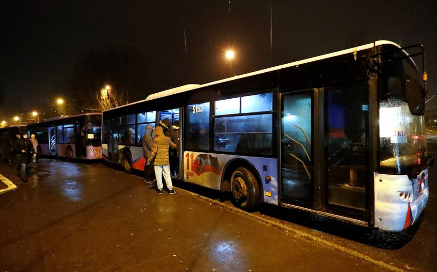 People board buses arranged to evacuate local residents, in Donetsk