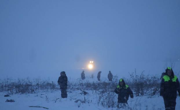 Emergency services work at the scene where a short-haul regional Antonov AN-148 plane crashed after taking off from Moscow