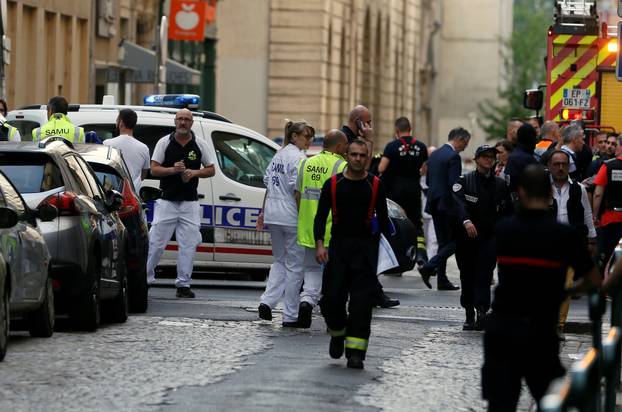 Police officers, fire fighters and medics are seen near the site of a suspected bomb attack in central Lyon