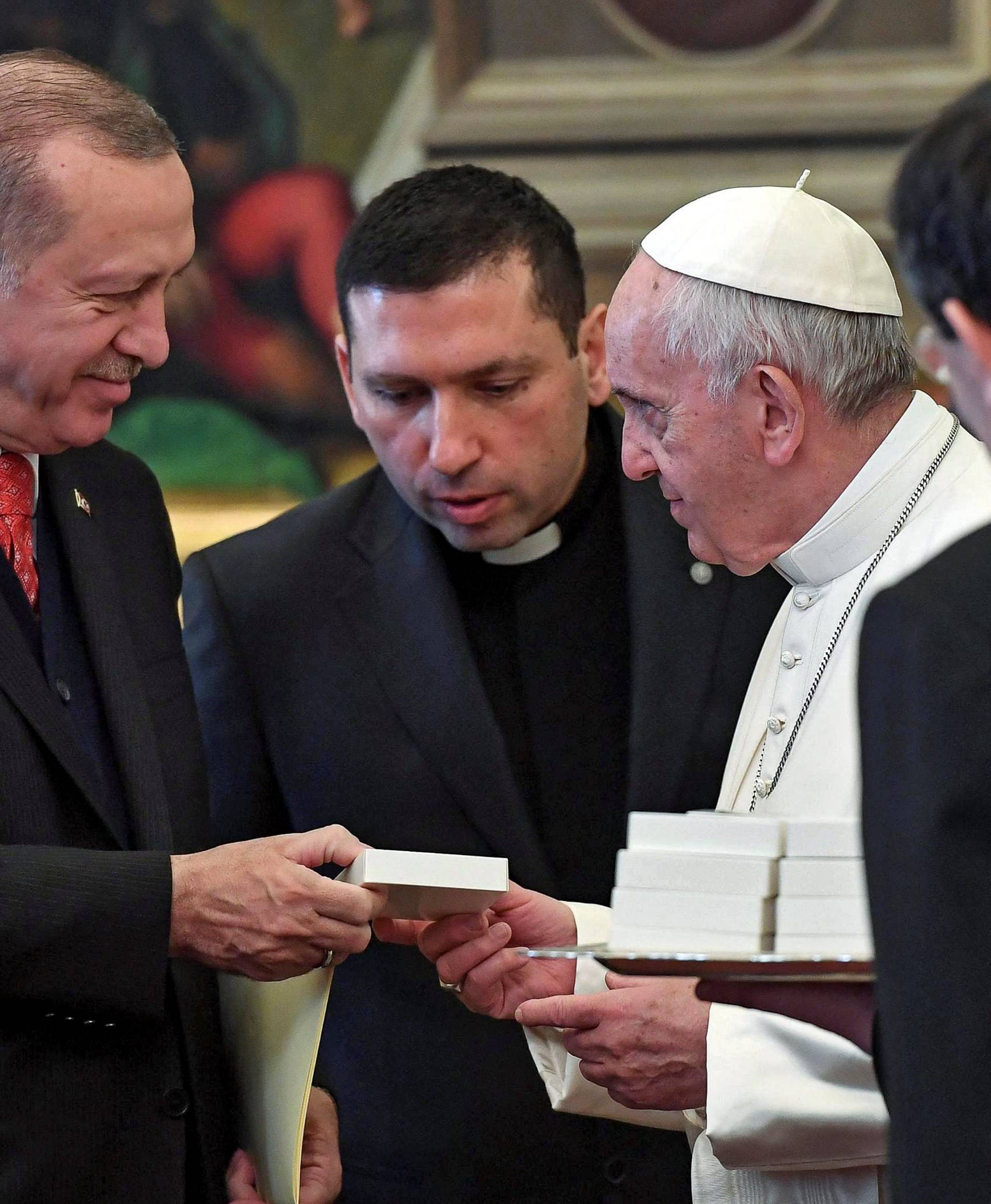 Pope Francis exchanges gift with Turkish President Tayyip Erdogan and his wife Emine during a private audience at the Vatican