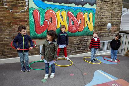 Children use hoops for social distancing at L'Ecole Des Petits school