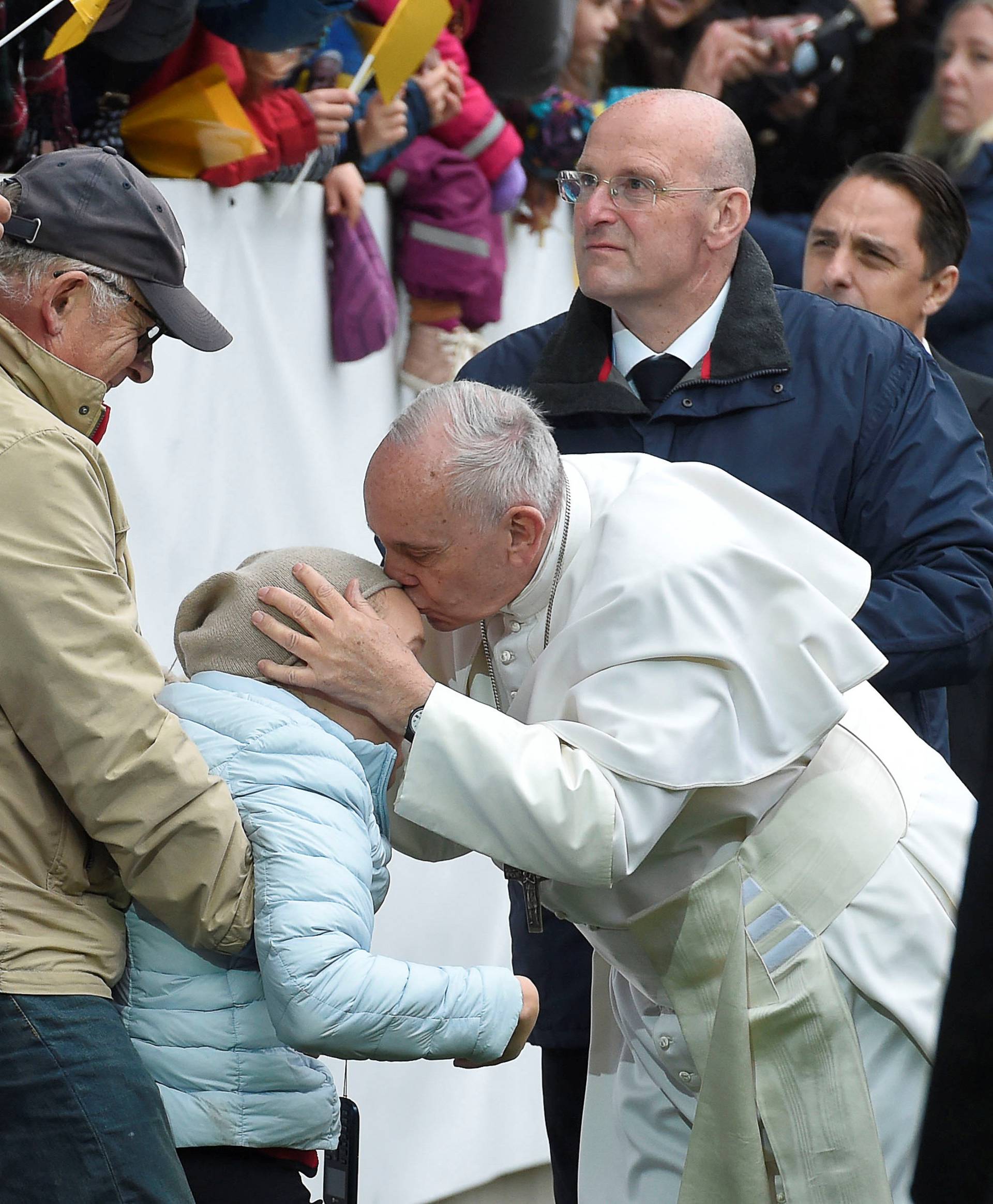 Pope Francis kisses a sick person as he arrives to lead a Holy Mass at the Swedbank Stadion in Malmo