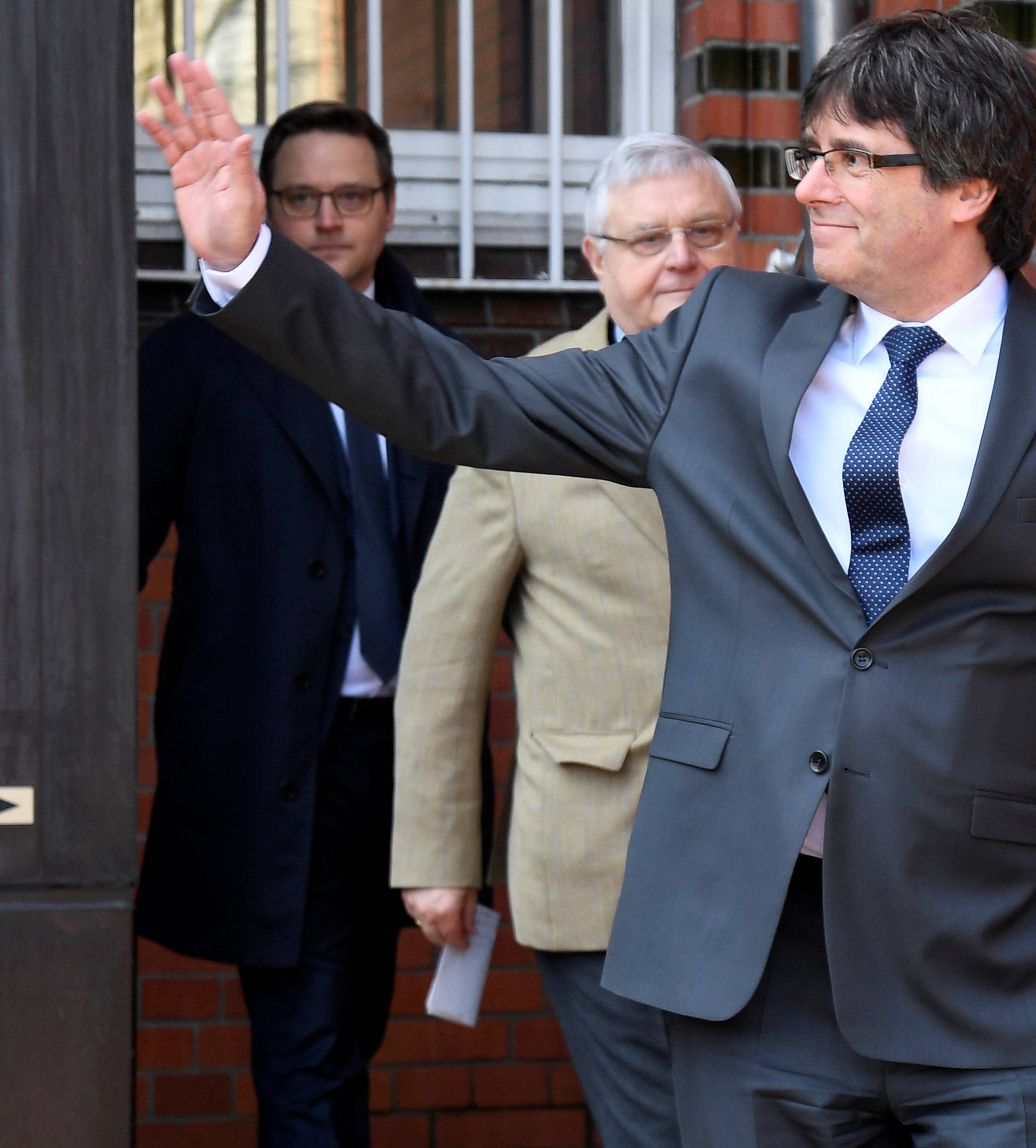 Catalonia's former leader Carles Puigdemont waves as he leaves the prison in Neumuenster